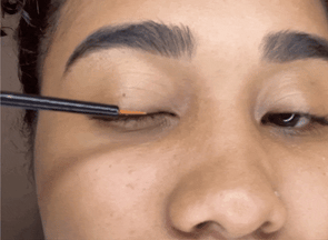 Woman applying Glimmr Long Lash Serum to her lashes